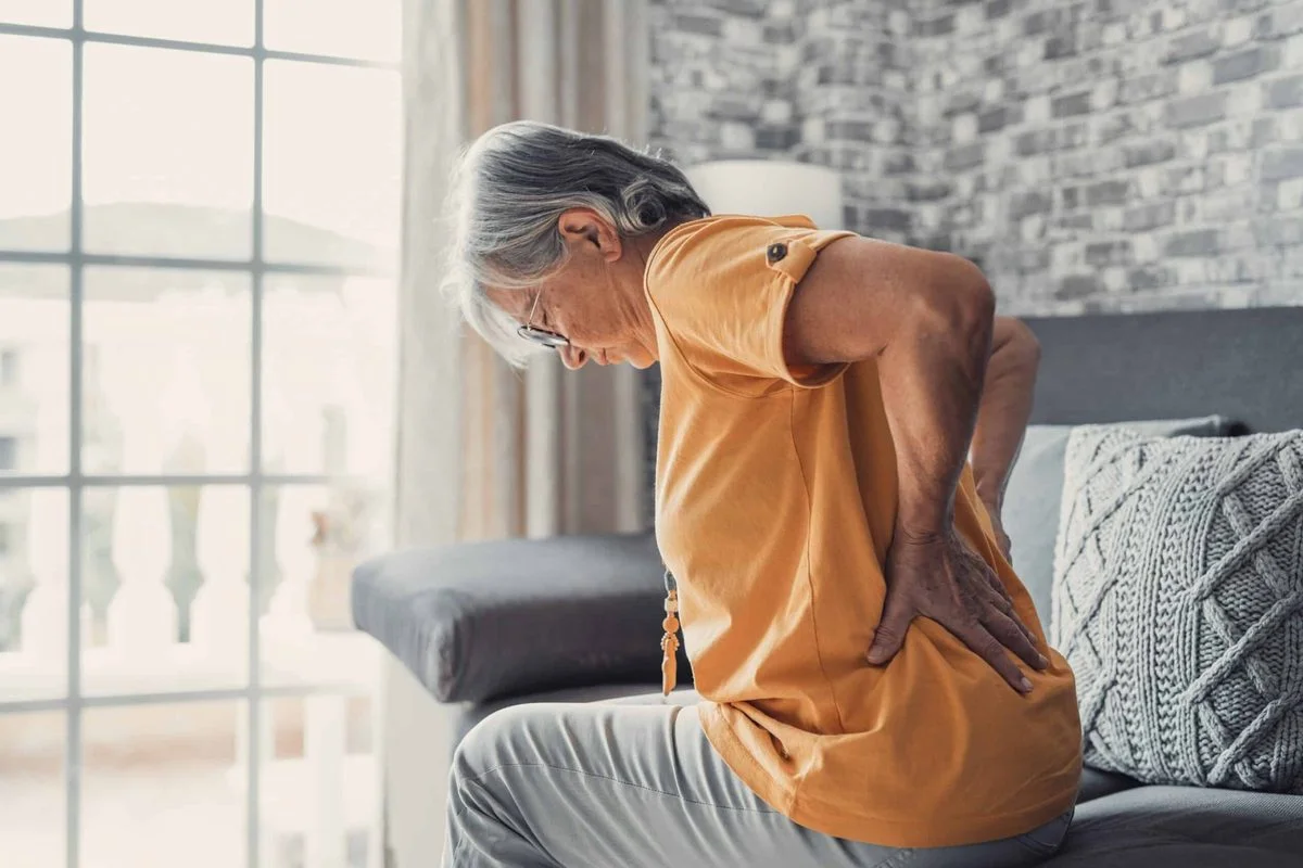 Mujer mayor sintiendo dolor ciático en la zona lumbar al sentarse